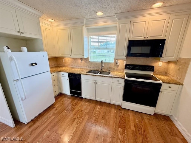 3700 26th St SW, Lehigh Acres, FL 33976 - kitchen with black appliances, a sink, backsplash, white cabinets, and light wood-style floors