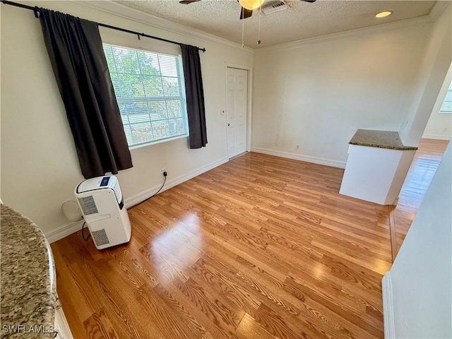 3700 26th St SW, Lehigh Acres, FL 33976 - spare room with a ceiling fan, light wood finished floors, ornamental molding, a textured ceiling, and baseboards