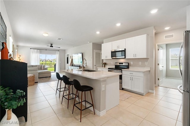 8833 Swell Brooks Ct, North Fort Myers, FL 33917 - kitchen with stainless steel appliances, a sink, open floor plan, a kitchen bar, and ceiling fan