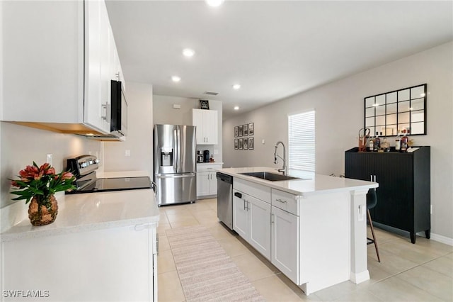 8833 Swell Brooks Ct, North Fort Myers, FL 33917 - kitchen with stainless steel appliances, a sink, light tile patterned flooring, white cabinetry, and light countertops