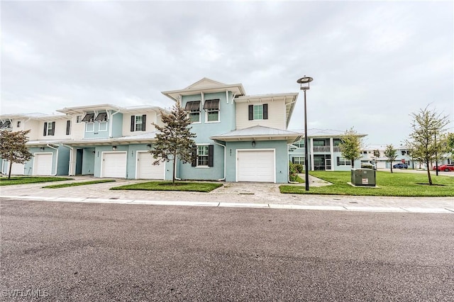 26401 Coco Cay Cir Unit 101, Bonita Springs, FL 34135 - view of front of property with a garage, stucco siding, driveway, and a front lawn