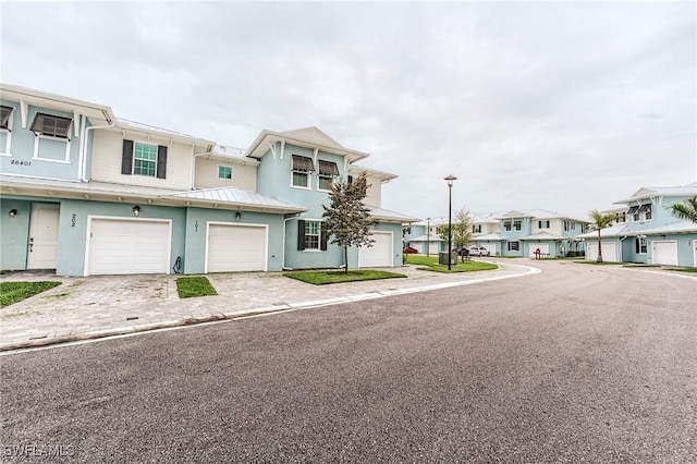 26401 Coco Cay Cir Unit 101, Bonita Springs, FL 34135 - view of property with a residential view, a standing seam roof, metal roof, stucco siding, and an attached garage