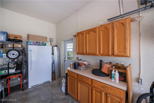 1115 Comet Ave, Labelle, FL 33935 - kitchen with freestanding refrigerator, light countertops, concrete floors, and brown cabinets