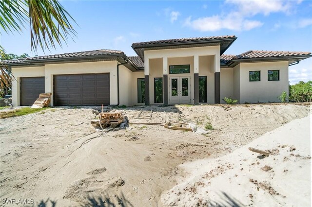 721 Golden Gate Blvd W, Naples, FL 34120 - view of front of house featuring french doors, an attached garage, stucco siding, and a tile roof