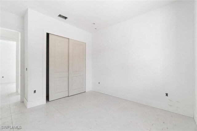 721 Golden Gate Blvd W, Naples, FL 34120 - unfurnished bedroom with a closet, baseboards, and concrete flooring