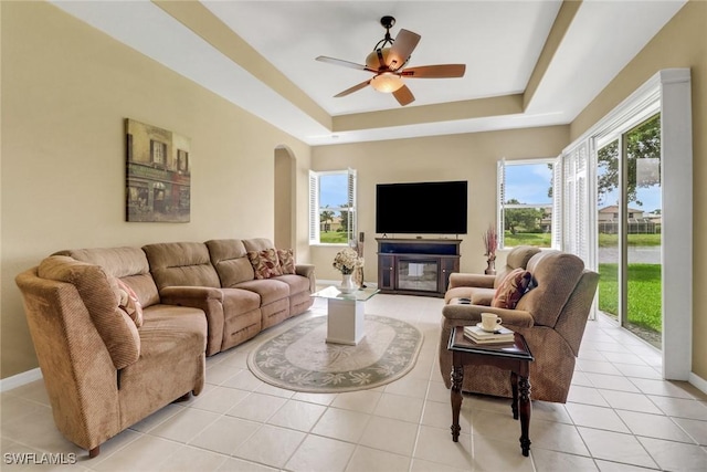 3032 Lake Manatee Ct, Cape Coral, FL 33909 - living room with a tray ceiling, arched walkways, light tile patterned floors, a ceiling fan, and baseboards