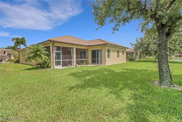 3032 Lake Manatee Ct, Cape Coral, FL 33909 - back of house with a tiled roof, a yard, a sunroom, and stucco siding