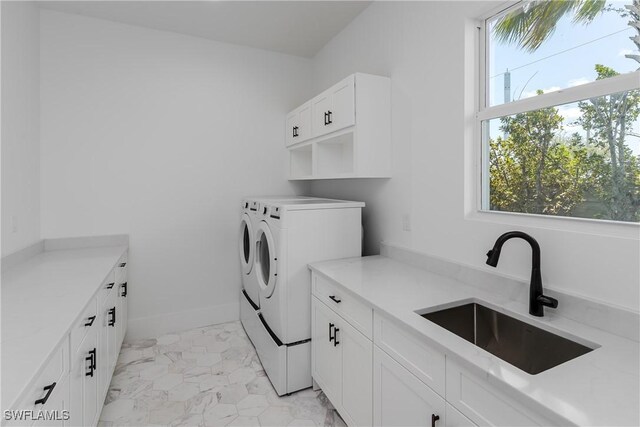 2854 Coach House Way, Naples, FL 34105 - laundry area with separate washer and dryer, cabinet space, light marble finish flooring, and baseboards