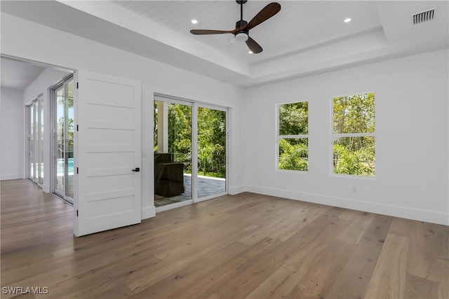 2854 Coach House Way, Naples, FL 34105 - empty room with hardwood / wood-style flooring, ceiling fan, a tray ceiling, baseboards, and recessed lighting