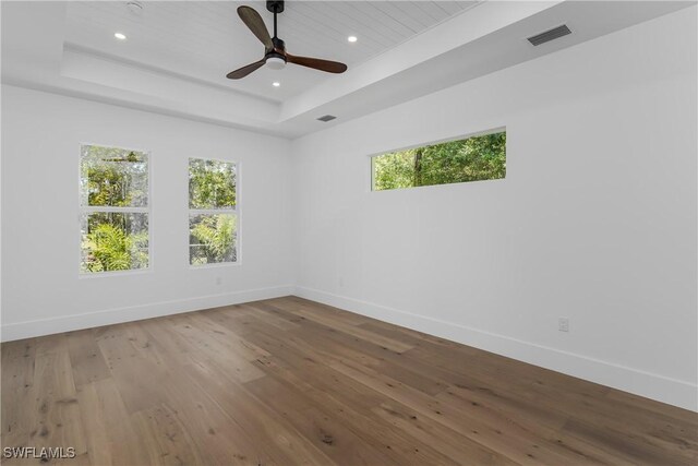 2854 Coach House Way, Naples, FL 34105 - empty room featuring plenty of natural light, a tray ceiling, baseboards, wood-type flooring, and recessed lighting