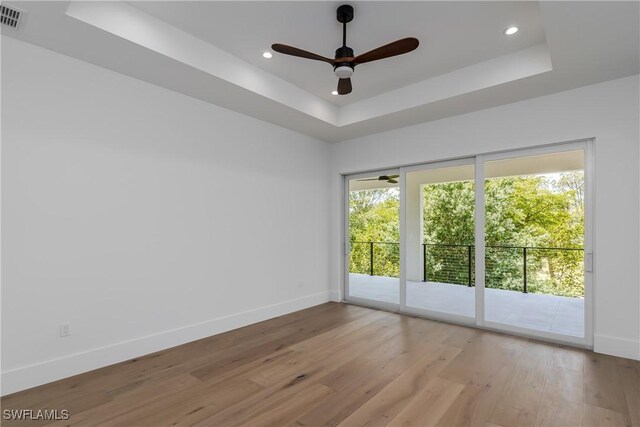 2854 Coach House Way, Naples, FL 34105 - spare room featuring ceiling fan, a tray ceiling, baseboards, light wood finished floors, and recessed lighting