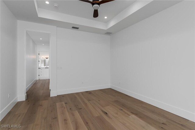 2854 Coach House Way, Naples, FL 34105 - empty room with recessed lighting, a raised ceiling, wood finished floors, baseboards, and a ceiling fan