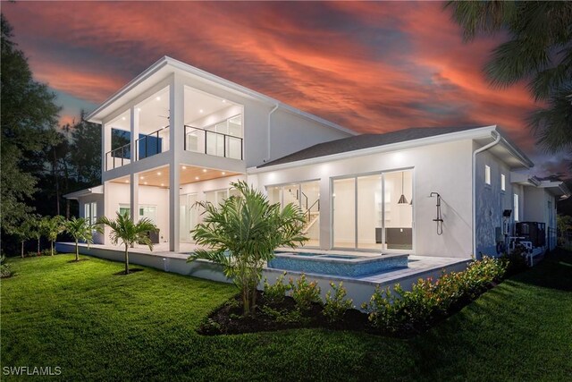 2854 Coach House Way, Naples, FL 34105 - back of property at dusk with stucco siding, a lawn, and a balcony