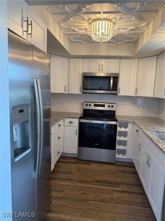 5499 Rattlesnake Hammock Rd Unit A 103, Naples, FL 34113 - kitchen featuring stainless steel appliances, white cabinets, a chandelier, backsplash, and dark wood-style flooring