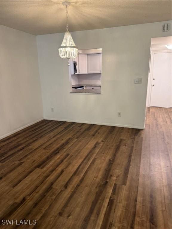 5499 Rattlesnake Hammock Rd Unit A 103, Naples, FL 34113 - unfurnished dining area with dark wood-style floors, a chandelier, and baseboards