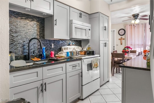 1154 4th Way N, Fort Myers, FL 33903 - kitchen featuring white appliances, backsplash, a ceiling fan, gray cabinetry, and dark stone counters