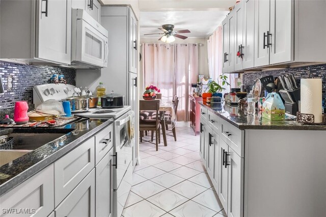 1154 4th Way N, Fort Myers, FL 33903 - kitchen featuring white appliances, decorative backsplash, a ceiling fan, light tile patterned flooring, and dark stone counters