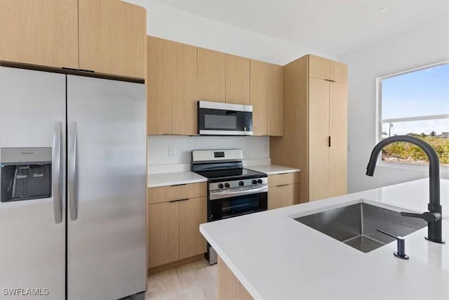 2902 61st St W, Lehigh Acres, FL 33971 - kitchen with stainless steel appliances, a sink, light countertops, and light brown cabinets