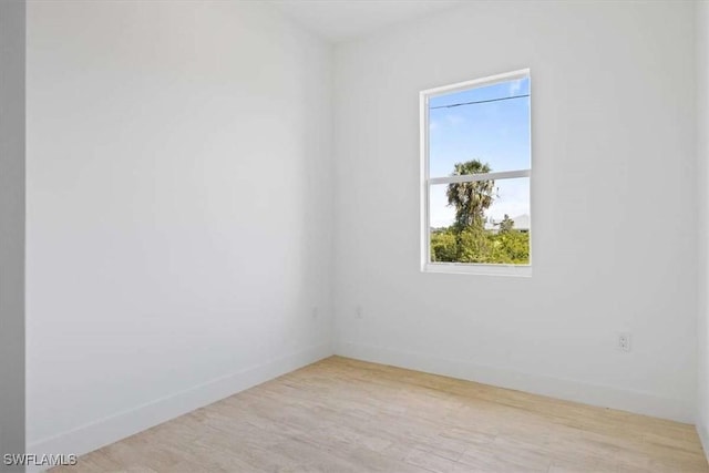 2902 61st St W, Lehigh Acres, FL 33971 - spare room featuring plenty of natural light, baseboards, and wood finished floors