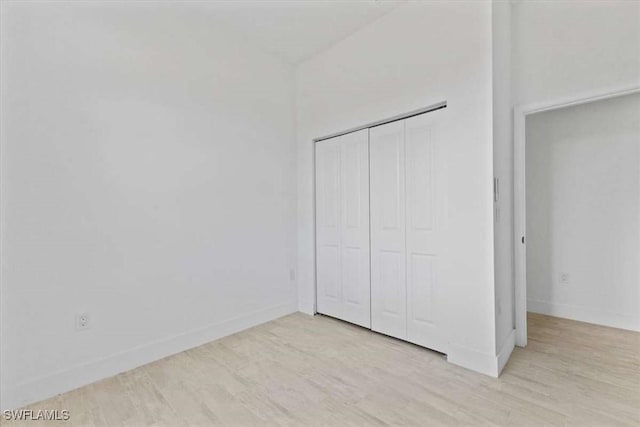 2902 61st St W, Lehigh Acres, FL 33971 - unfurnished bedroom featuring light wood-style flooring, baseboards, and a closet