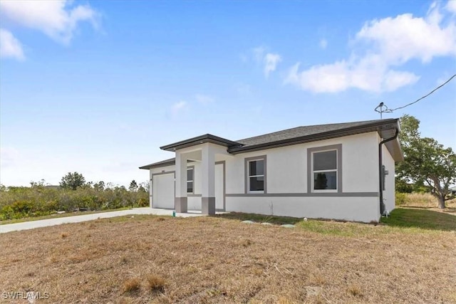 2902 61st St W, Lehigh Acres, FL 33971 - view of front of property featuring an attached garage, concrete driveway, and stucco siding