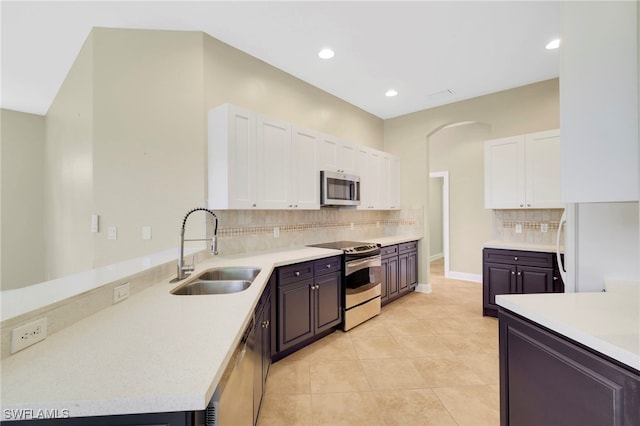 16162 Coco Hammock Way, Fort Myers, FL 33908 - kitchen with stainless steel appliances, a sink, white cabinetry, decorative backsplash, and light countertops