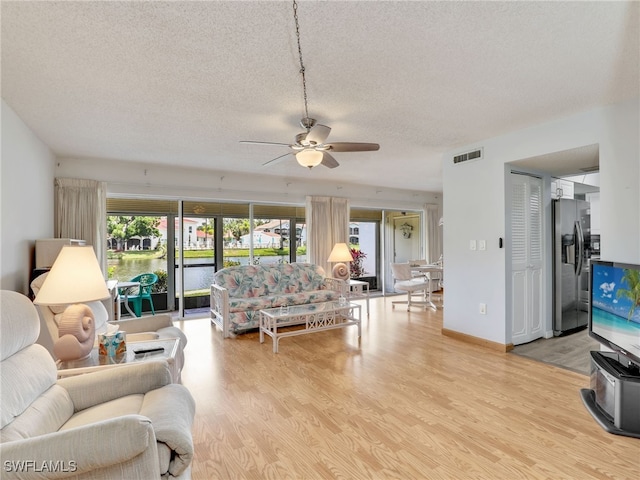 5479 Peppertree Dr Unit 13, Fort Myers, FL 33908 - living area with a textured ceiling, wood finished floors, ceiling fan, and a water view