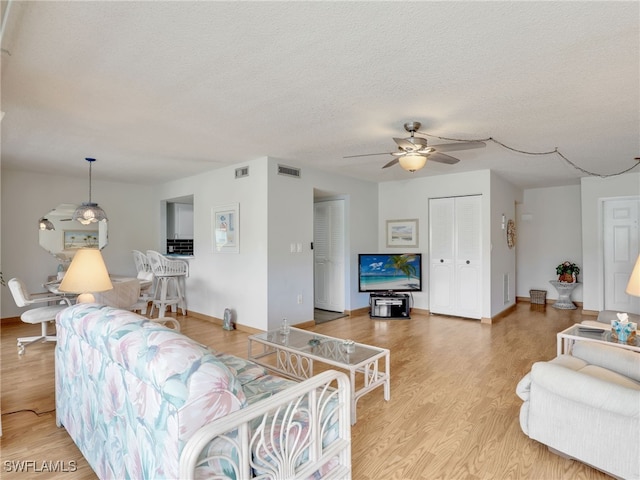 5479 Peppertree Dr Unit 13, Fort Myers, FL 33908 - living room featuring ceiling fan, light wood-style flooring, a textured ceiling, and baseboards