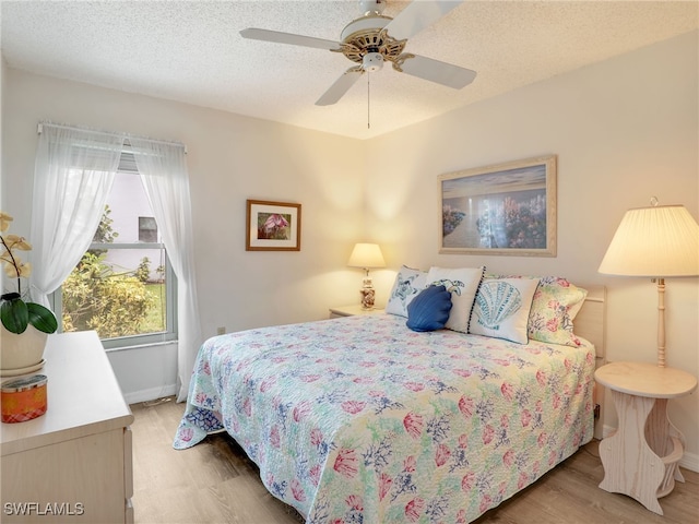 5479 Peppertree Dr Unit 13, Fort Myers, FL 33908 - bedroom with light wood-style flooring, baseboards, a ceiling fan, and a textured ceiling