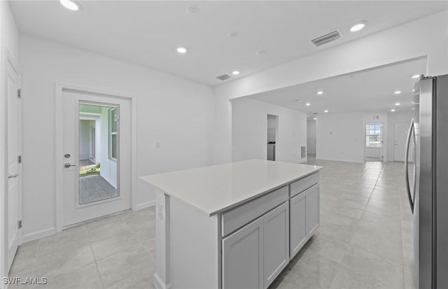 44225 Kelly Dr, Punta Gorda, FL 33982 - kitchen with freestanding refrigerator, light tile patterned floors, a center island, recessed lighting, and light countertops
