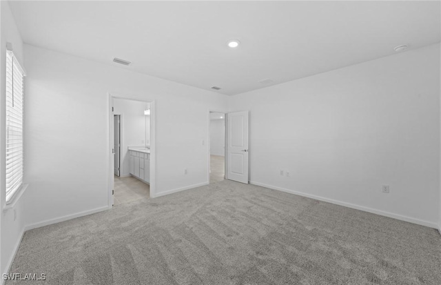 44225 Kelly Dr, Punta Gorda, FL 33982 - unfurnished bedroom featuring light colored carpet, baseboards, and ensuite bath