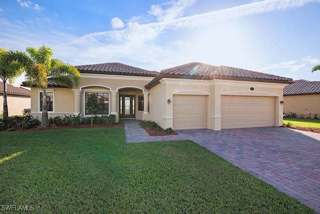 10114 Biscayne Bay Ln, Naples, FL 34120 - mediterranean / spanish-style house with decorative driveway, an attached garage, a front lawn, stucco siding, and a tile roof