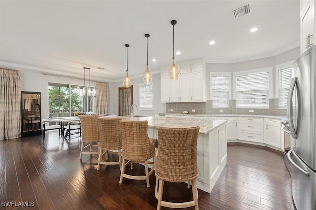 646 Vintage Reserve Cir Unit 4D, Naples, FL 34119 - kitchen with freestanding refrigerator, dark wood-style flooring, decorative backsplash, ornamental molding, and light stone counters