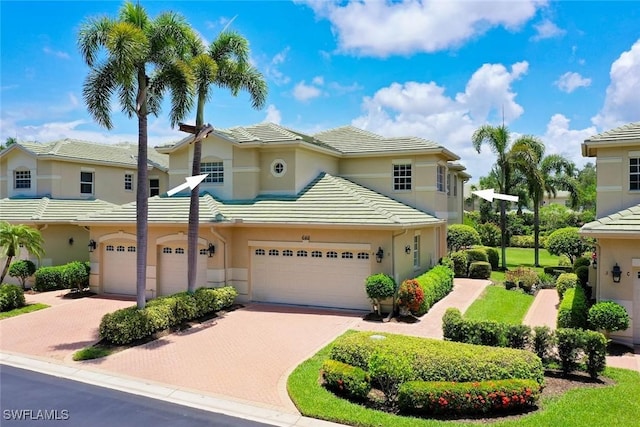 646 Vintage Reserve Cir Unit 4D, Naples, FL 34119 - view of property with decorative driveway, a garage, stucco siding, and a tiled roof