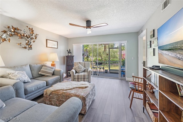 5741 Whitaker Rd Unit D103, Naples, FL 34112 - living area with wood finished floors, ceiling fan, and a textured ceiling