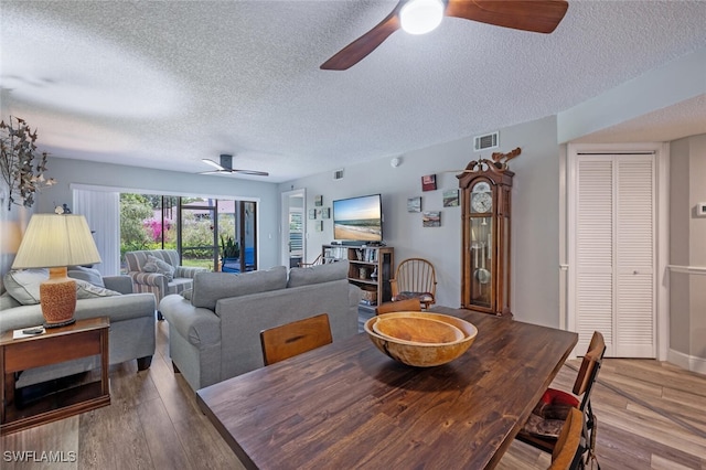 5741 Whitaker Rd Unit D103, Naples, FL 34112 - dining area with a ceiling fan, wood finished floors, and a textured ceiling