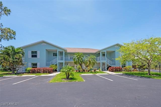 5741 Whitaker Rd Unit D103, Naples, FL 34112 - view of property with stairway and uncovered parking