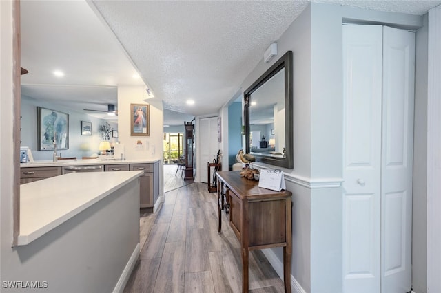 5741 Whitaker Rd Unit D103, Naples, FL 34112 - hallway featuring a textured ceiling, light wood-type flooring, and recessed lighting