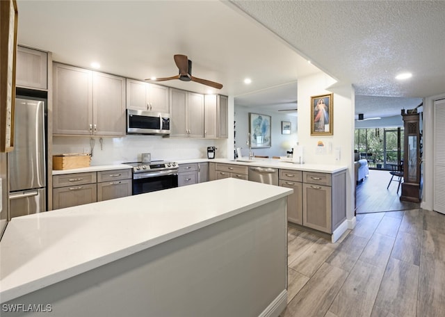 5741 Whitaker Rd Unit D103, Naples, FL 34112 - kitchen featuring appliances with stainless steel finishes, ceiling fan, a sink, light wood finished floors, and light countertops