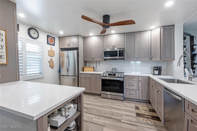 5741 Whitaker Rd Unit D103, Naples, FL 34112 - kitchen featuring appliances with stainless steel finishes, a sink, a ceiling fan, gray cabinetry, and light countertops