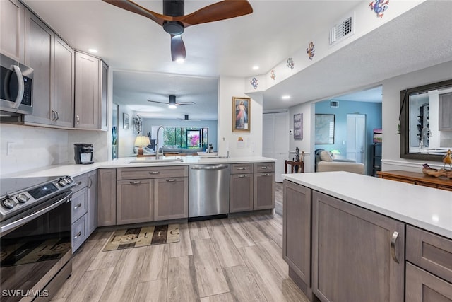 5741 Whitaker Rd Unit D103, Naples, FL 34112 - kitchen featuring appliances with stainless steel finishes, ceiling fan, open floor plan, a sink, and recessed lighting