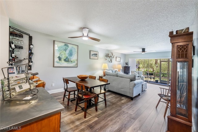 5741 Whitaker Rd Unit D103, Naples, FL 34112 - dining area featuring ceiling fan, a textured ceiling, dark wood-style floors, and baseboards