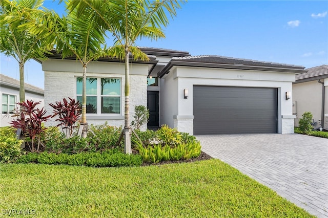 12467 Purple Ficus Way, Naples, FL 34120 - prairie-style house with stucco siding, a garage, a front lawn, driveway, and a tile roof