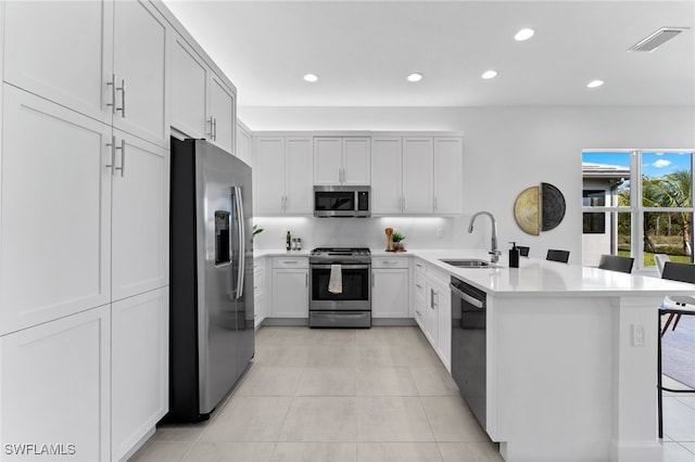 12467 Purple Ficus Way, Naples, FL 34120 - kitchen with stainless steel appliances, a sink, a peninsula, recessed lighting, and light tile patterned floors