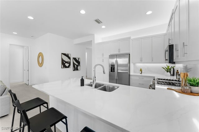 12467 Purple Ficus Way, Naples, FL 34120 - kitchen with a sink, appliances with stainless steel finishes, a peninsula, recessed lighting, and a kitchen breakfast bar