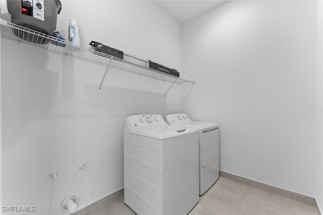 12467 Purple Ficus Way, Naples, FL 34120 - laundry area featuring washer and dryer, baseboards, and light tile patterned floors
