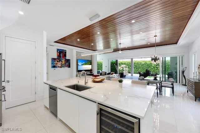 1167 22nd Ave N, Naples, FL 34103 - kitchen featuring beverage cooler, a sink, light tile patterned flooring, a raised ceiling, and open floor plan