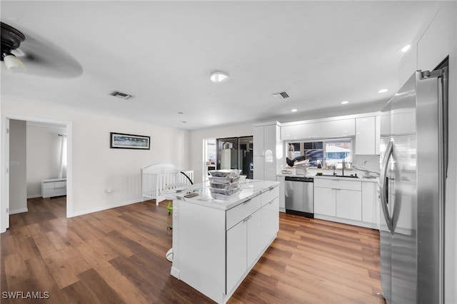 14260 Mcgregor Blvd, Fort Myers, FL 33919 - kitchen with stainless steel appliances, modern cabinets, wood finished floors, white cabinetry, and recessed lighting