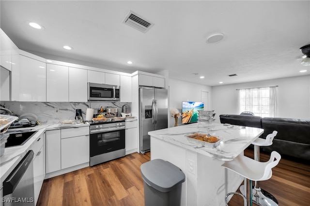 14260 Mcgregor Blvd, Fort Myers, FL 33919 - kitchen with appliances with stainless steel finishes, a kitchen bar, modern cabinets, open floor plan, and white cabinets