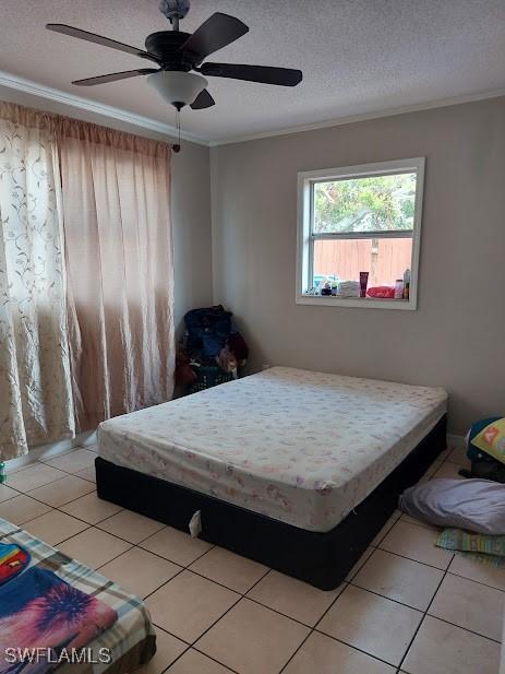 11421 Kimble Dr Unit 423, Fort Myers, FL 33908 - bedroom featuring crown molding, light tile patterned floors, a textured ceiling, and a ceiling fan